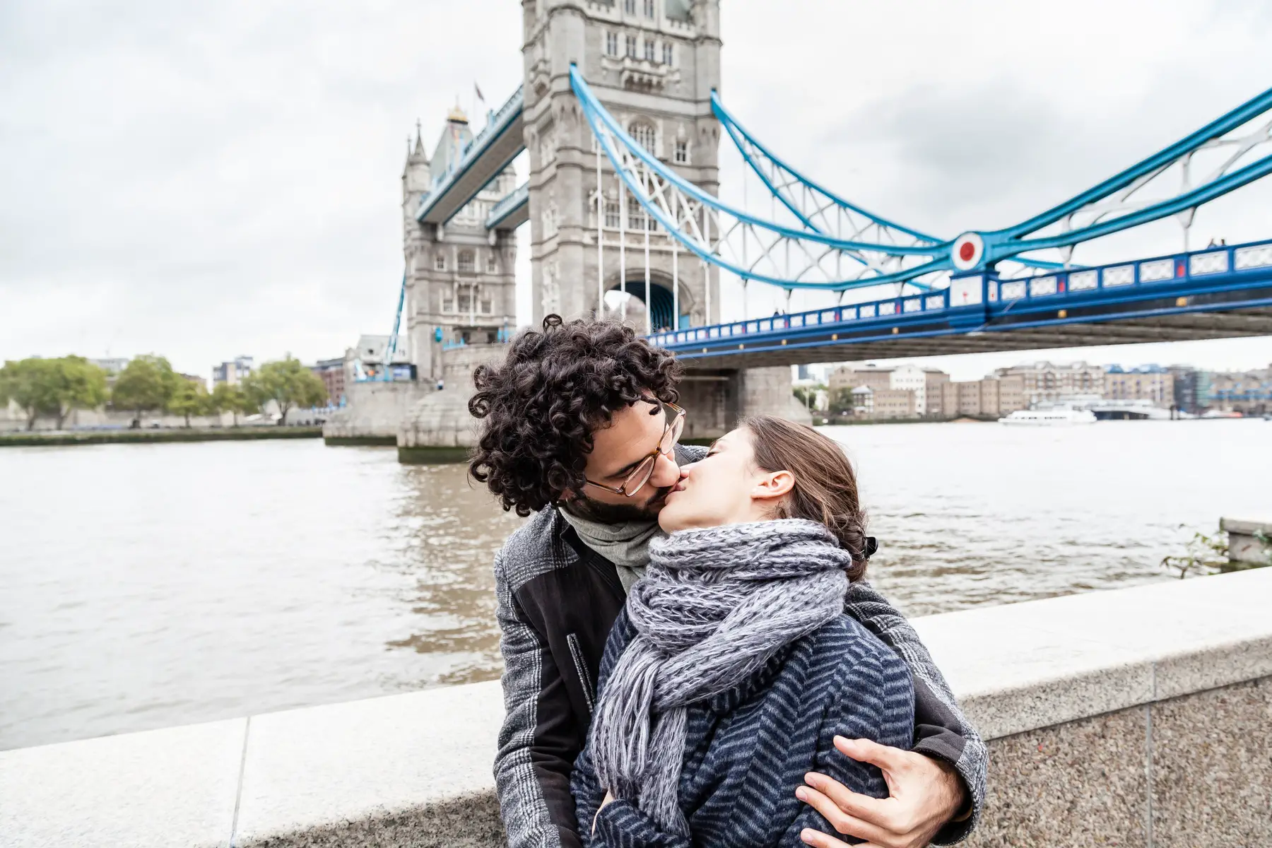 A couple kissing in front of the Tower Bridge