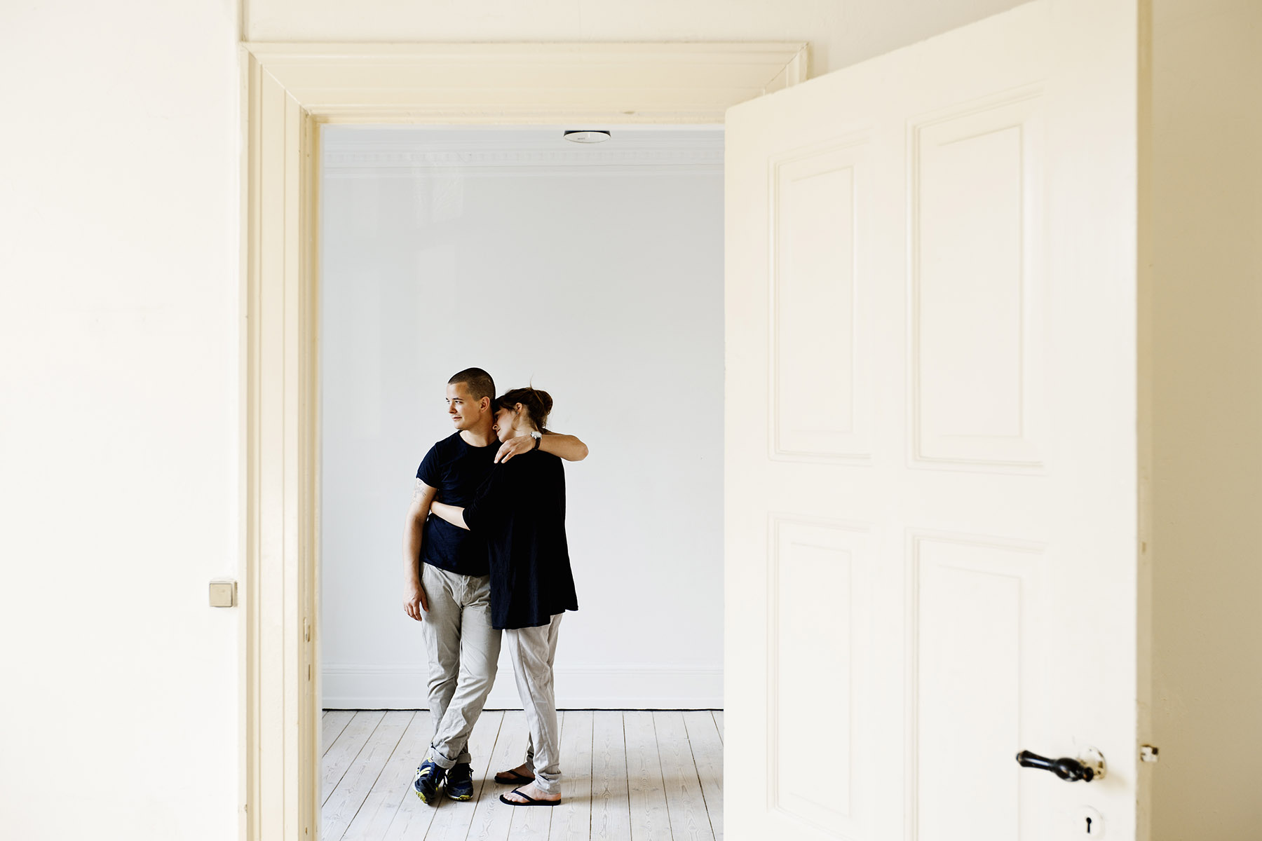 couple hugging standing in an empty house at the start of their new life.