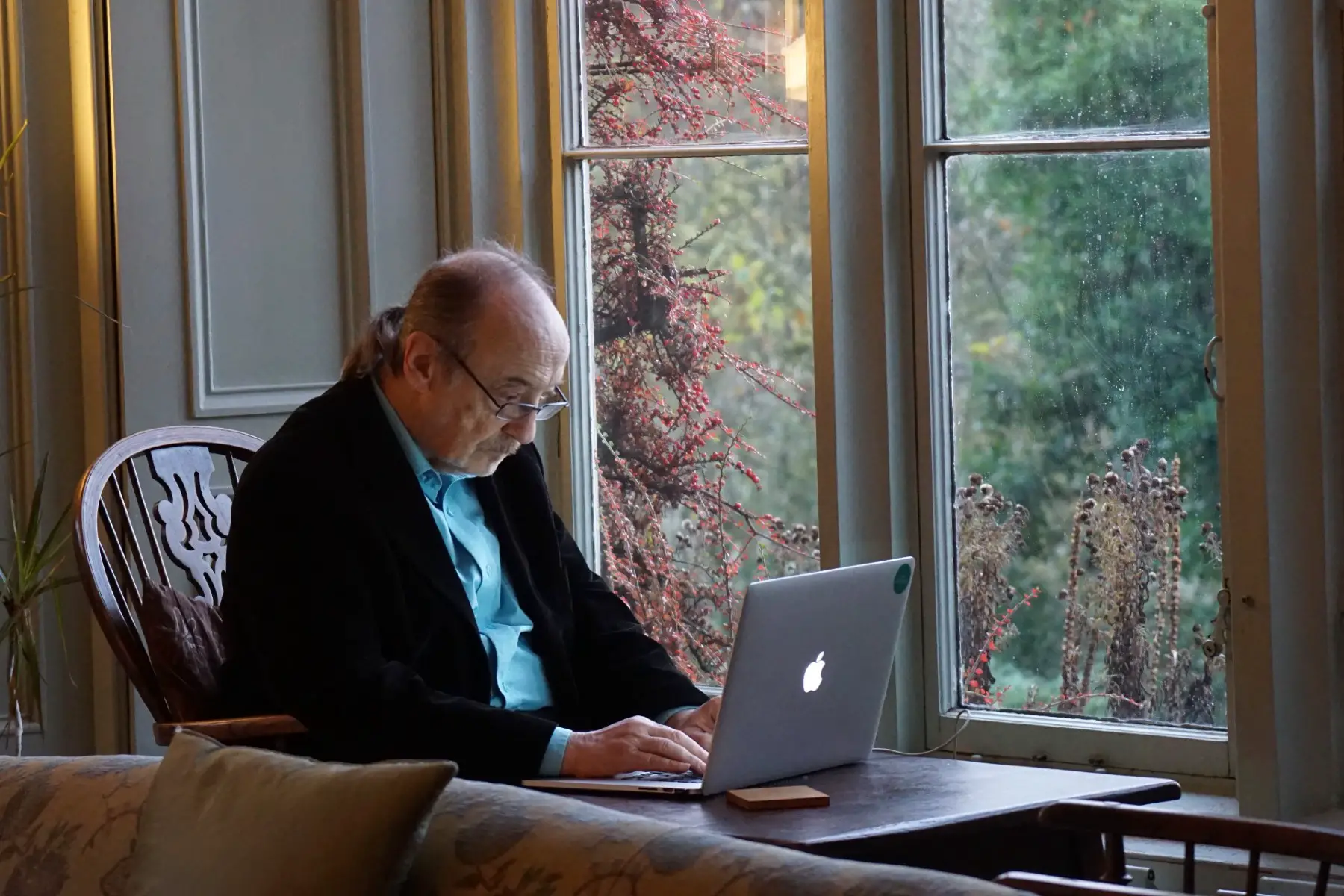 Philosopher George Pór looking at his laptop. Hawkwood College in Stroud, UK.