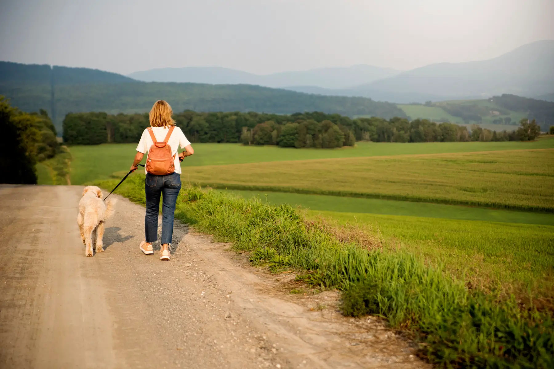 Woman walking dog in Canadian countryside