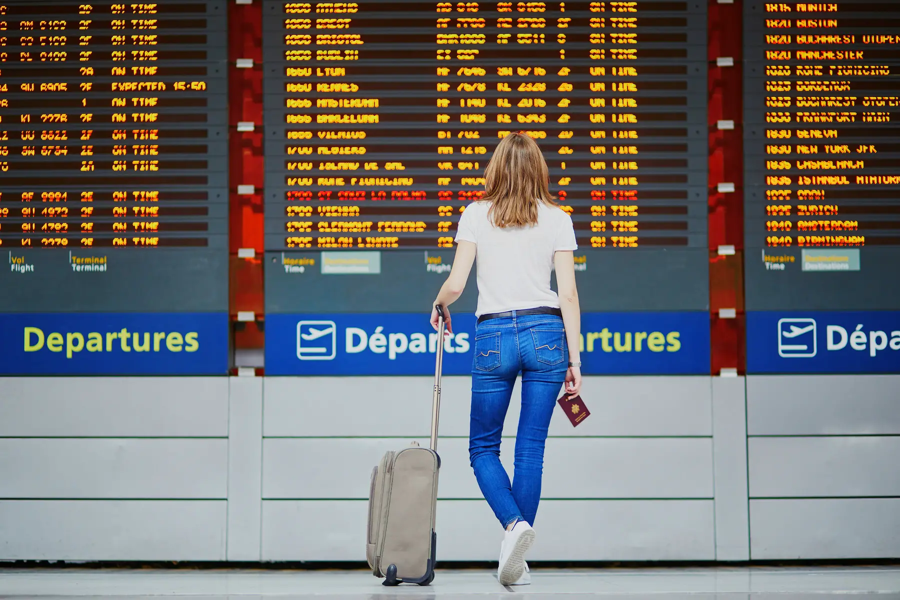 Young woman looking at an airport departure board