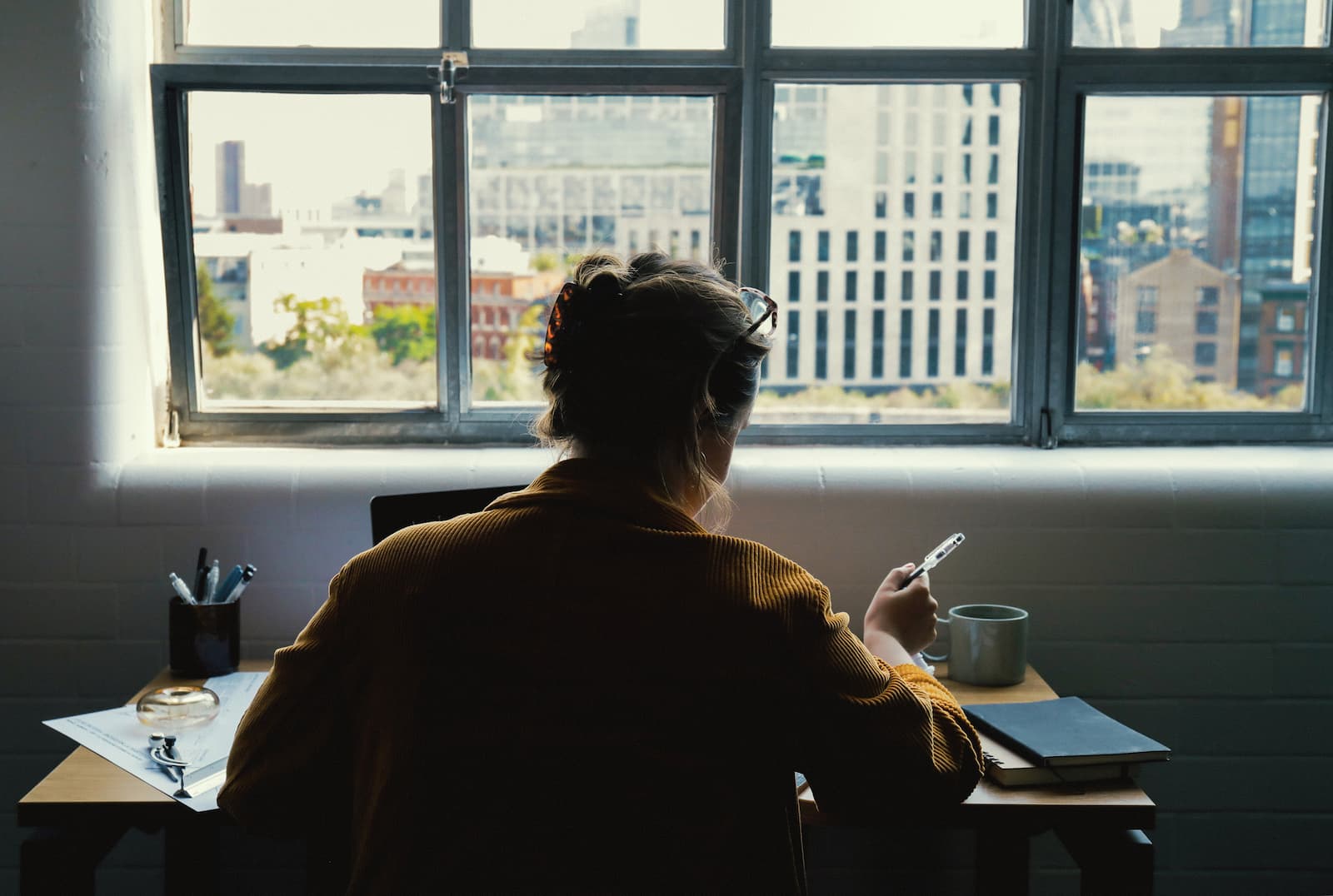 Freelancer working at her laptop by a window.