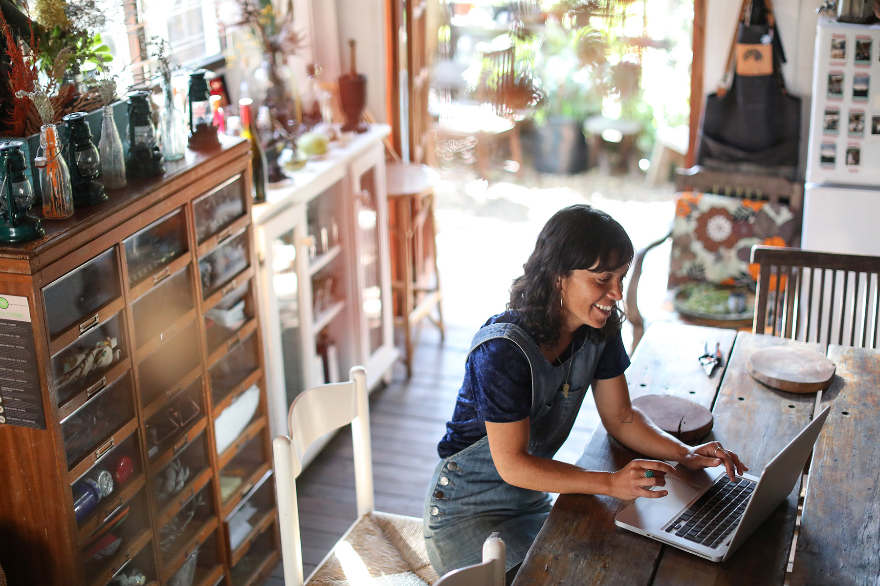 High angle shot of a woman sitting in her home office/kitchen working on her laptop