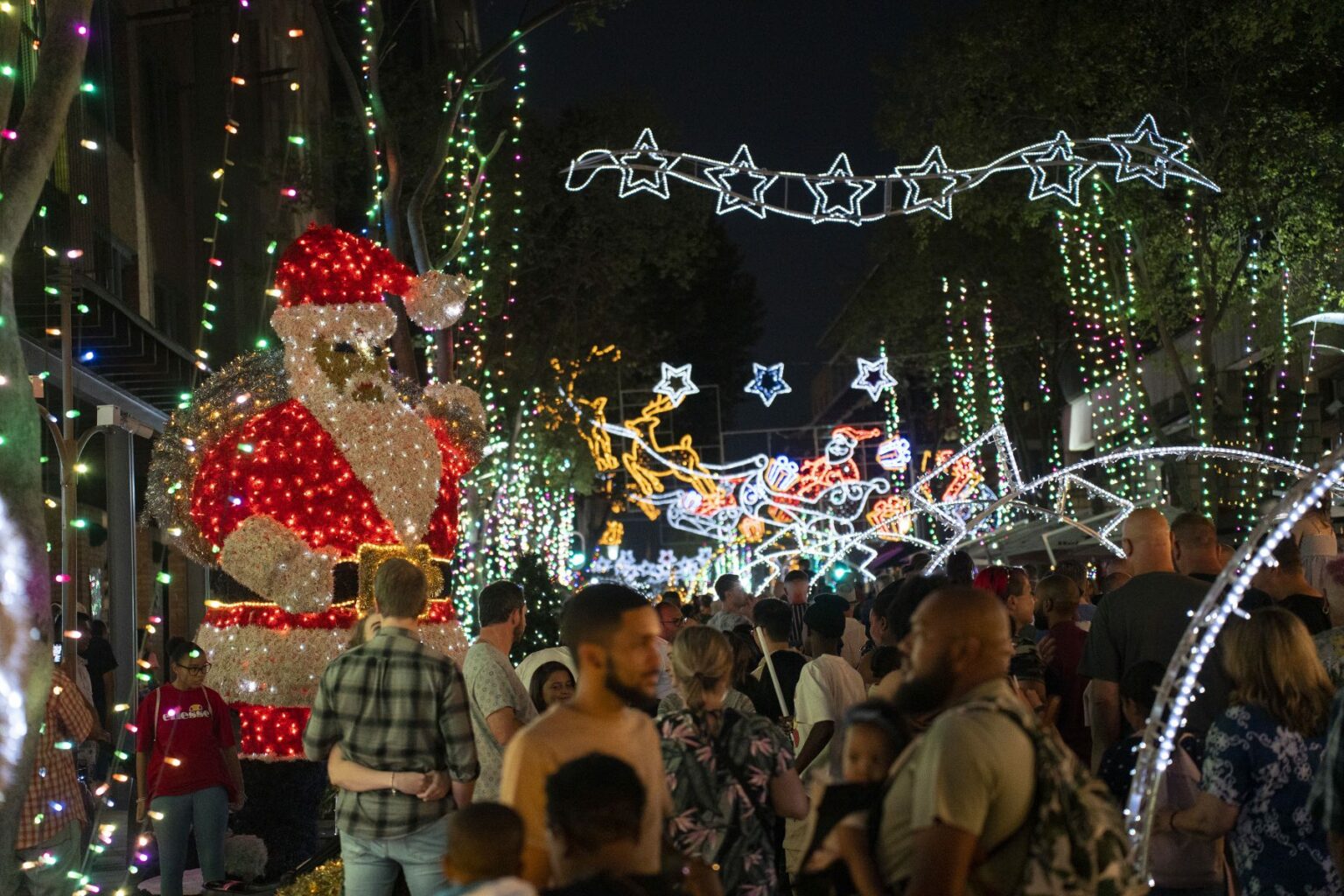 Christmas decoration illuminate a busy street in Johannesburg, with a light up Santa Claus
