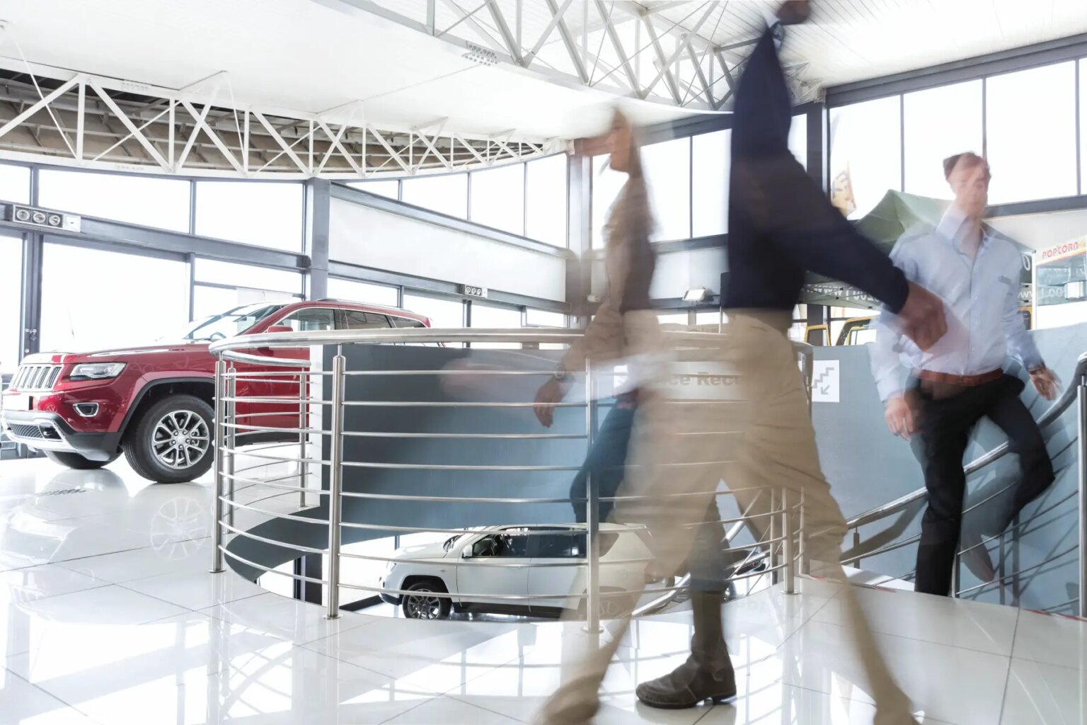Motion blur of people walking past a car at the dealership