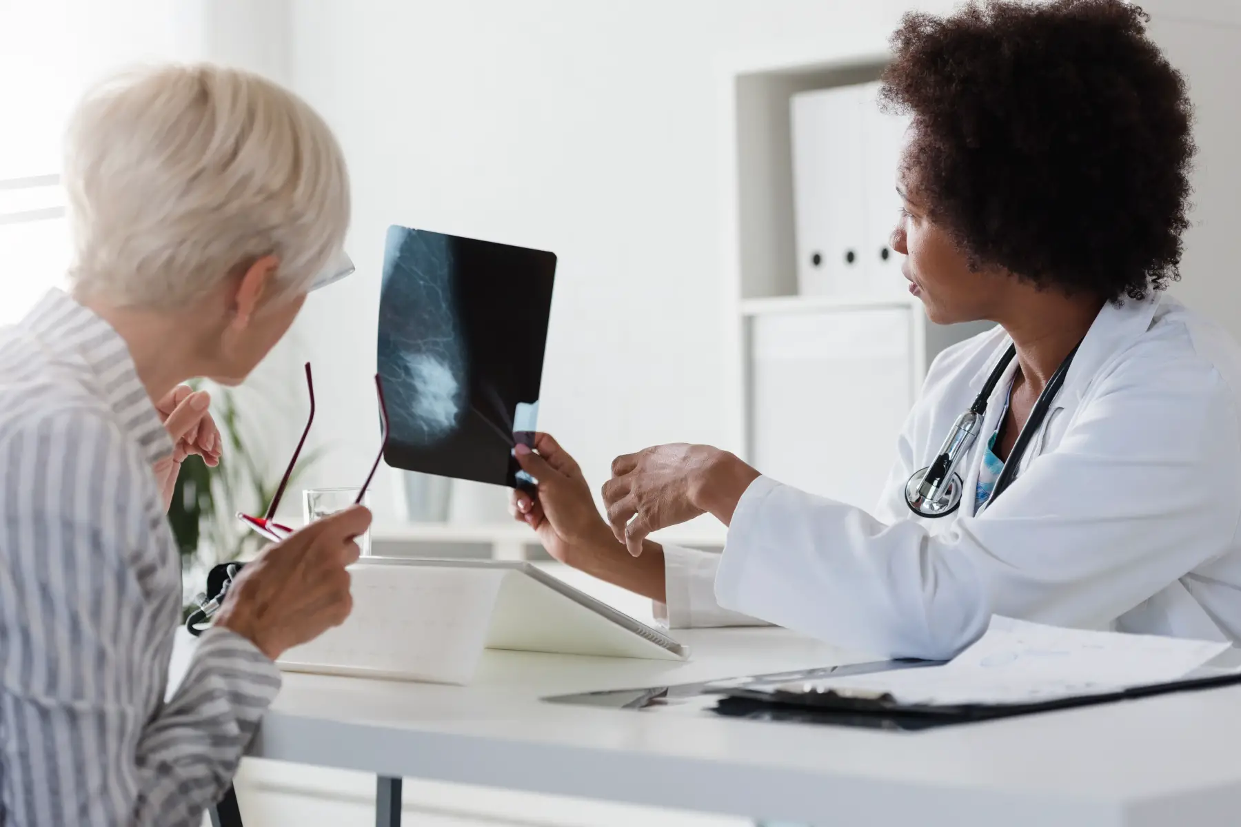 A doctor shows her patient a mammogram result