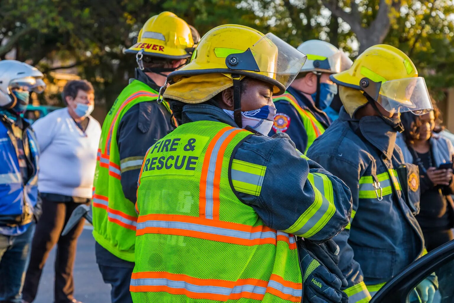 First responders with high visibility vests and helmets at an accident scene responding to an emergency