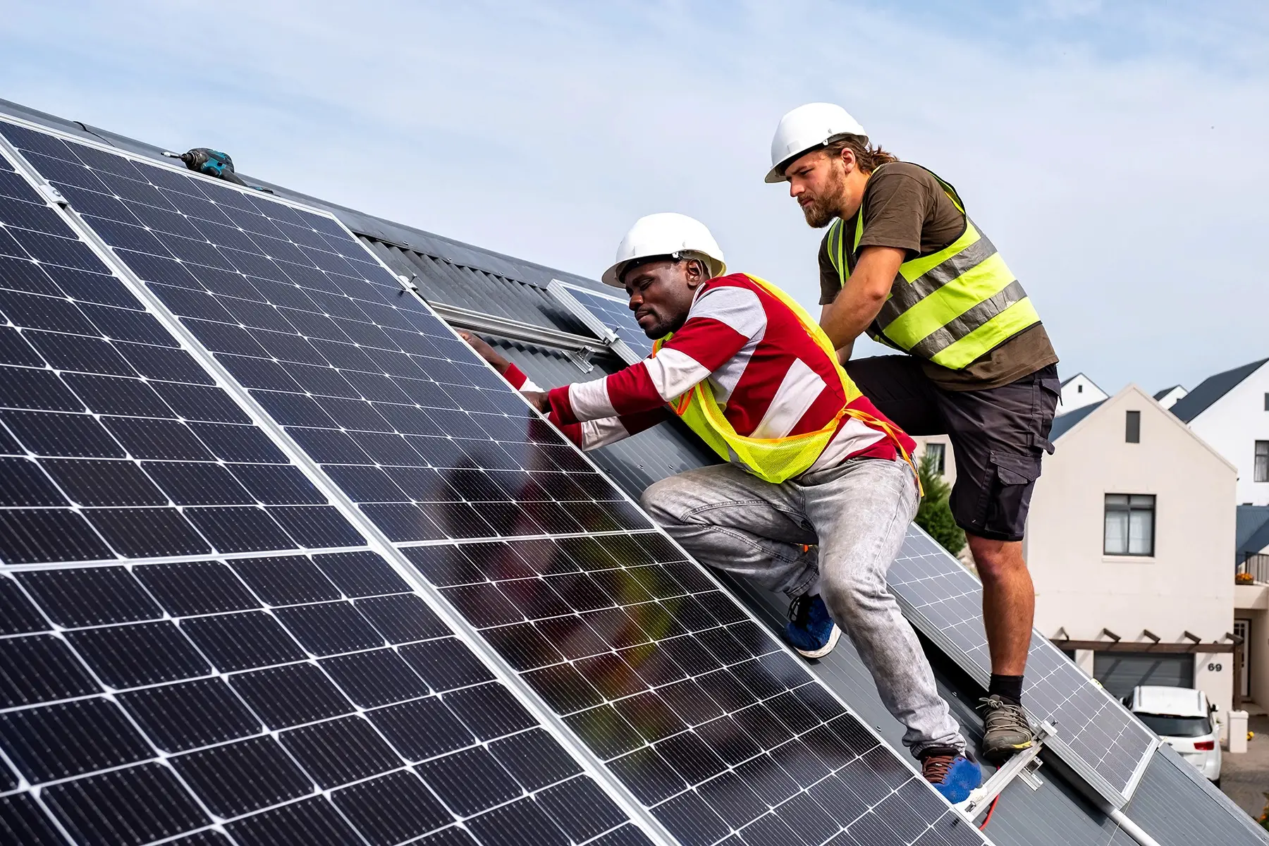 Technicians carefully connect and install solar panels on a residential rooftop on a house in South Africa