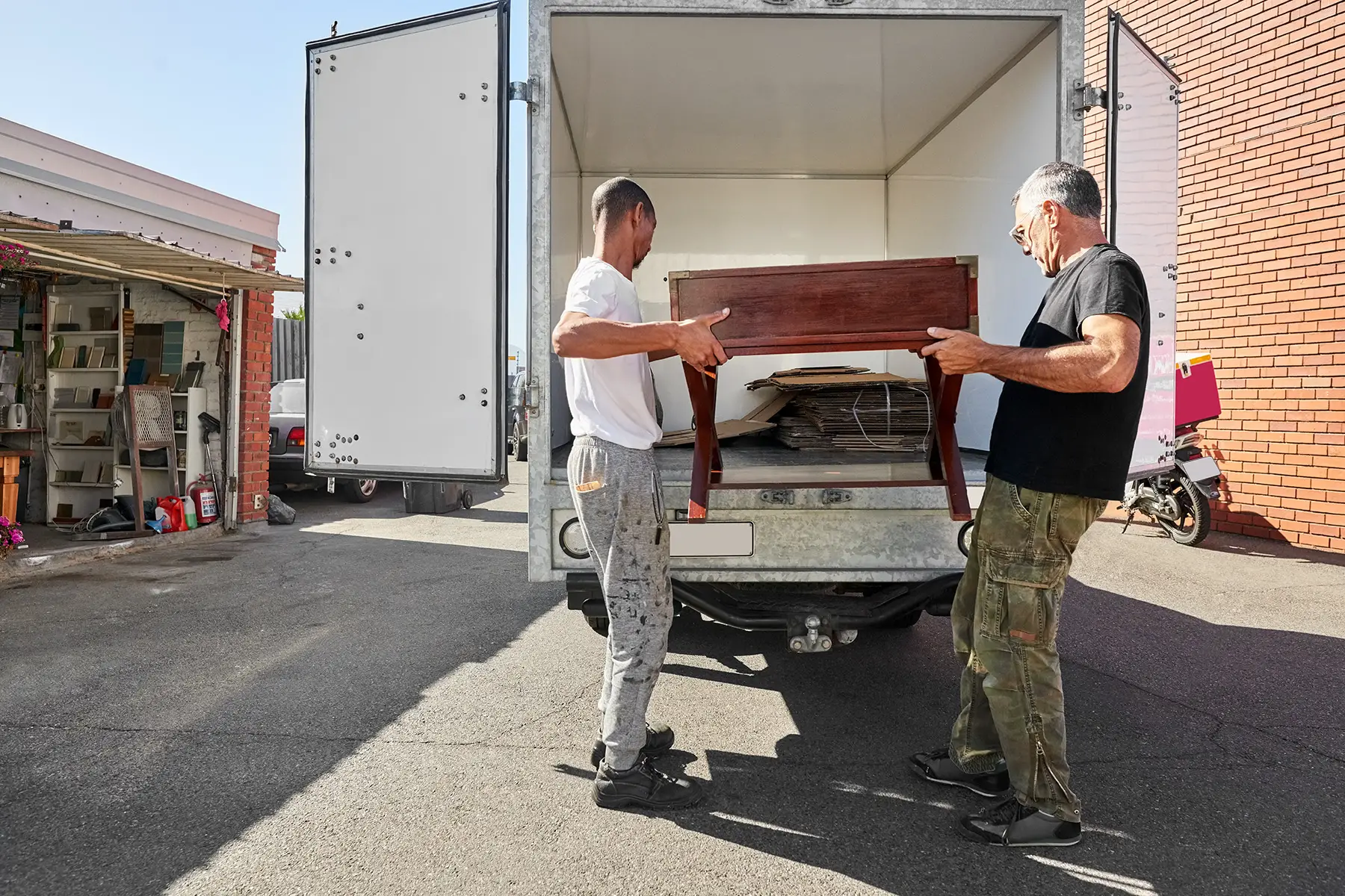 Two men loading furniture into a moving truck