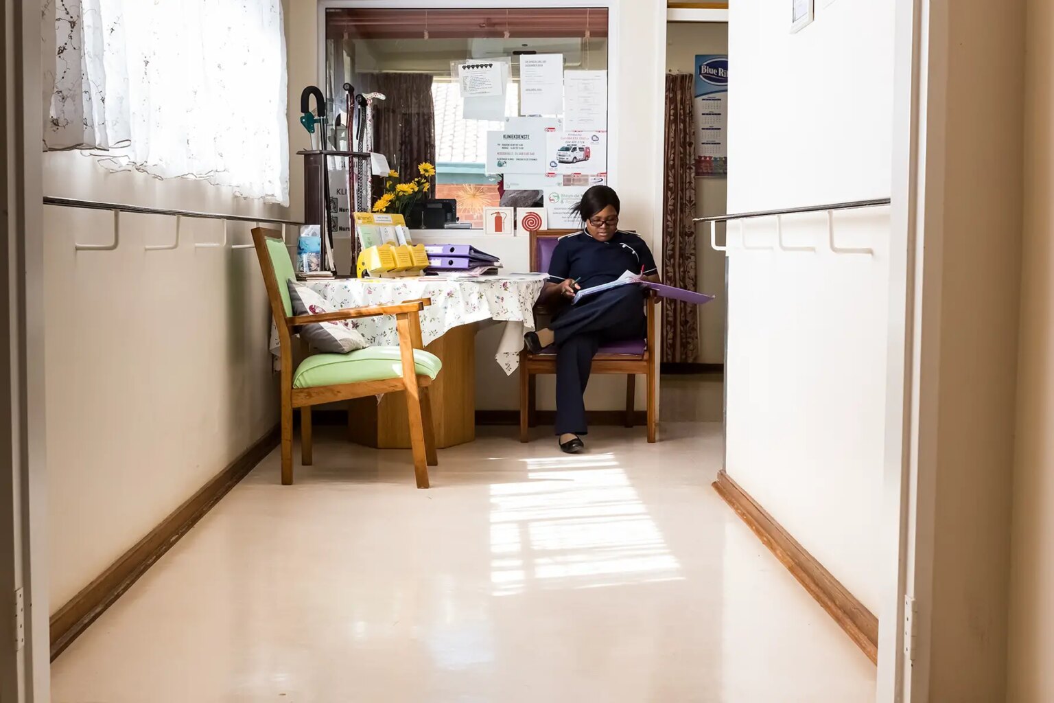 A person sitting in the hallway of a retirement home