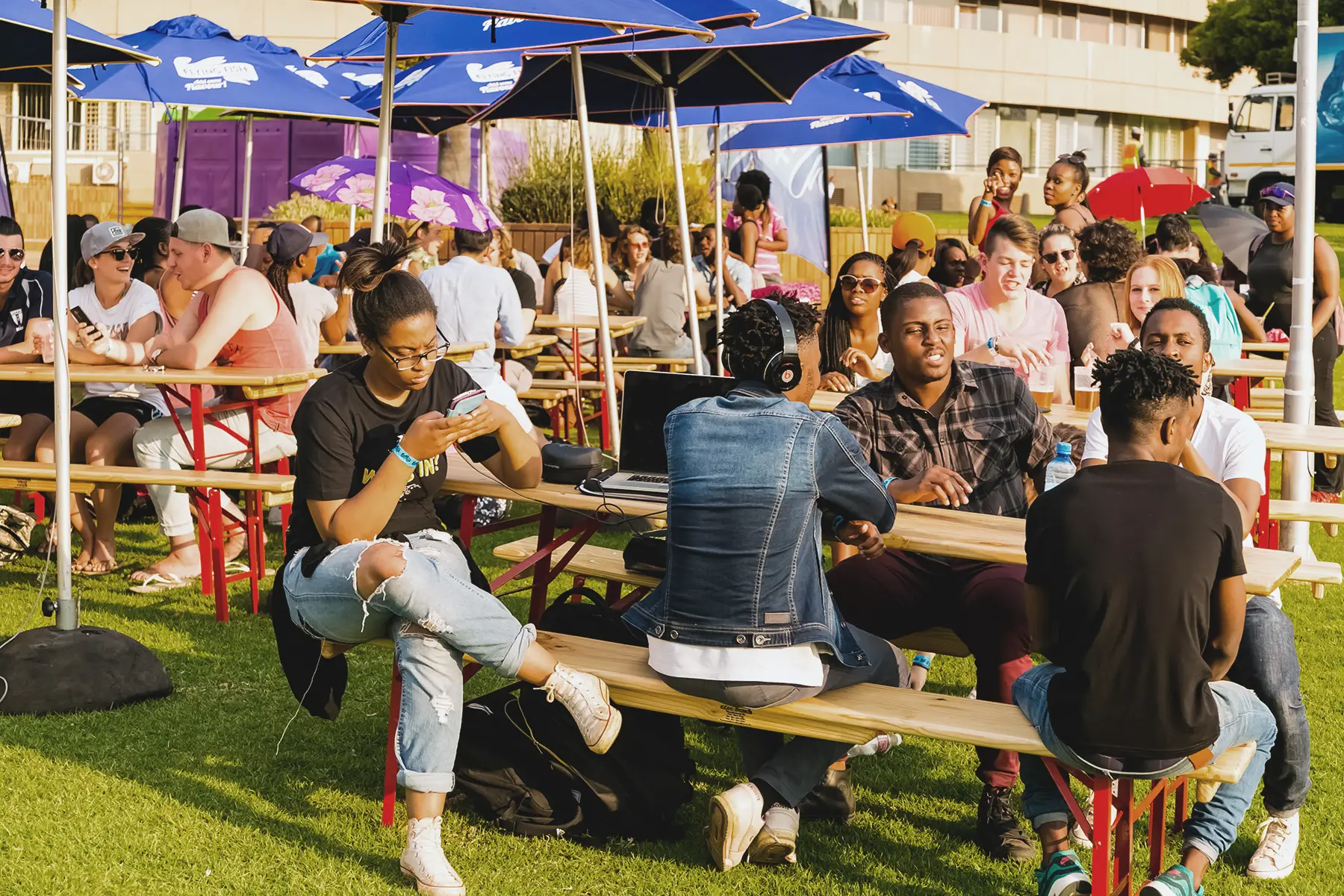 A diverse young people sitting at the tables at the outdoor beer garden in Johannesburg, South Africa