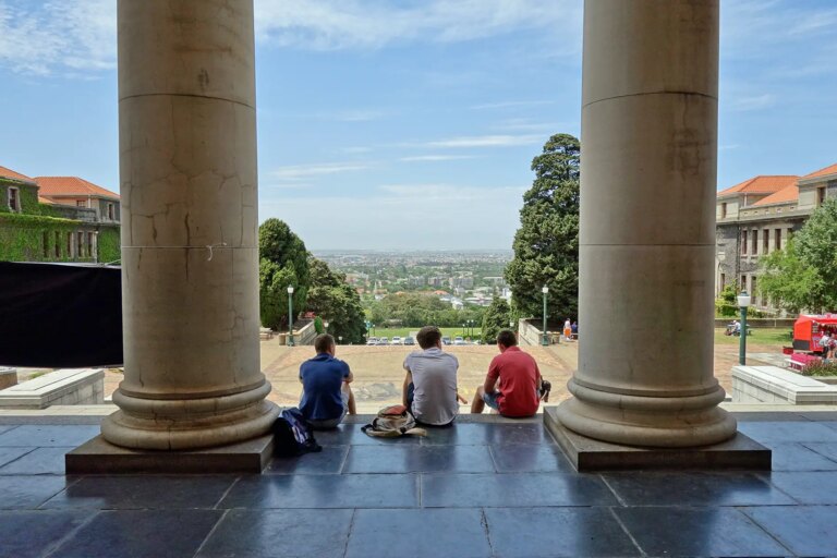 Students sitting on steps with a grat view